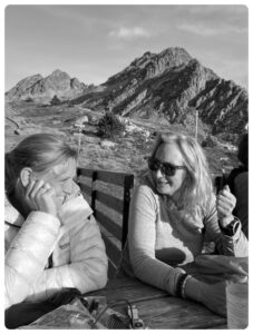 Black and white natural portrait of Angela Philp and Anne Arran in conversation in the mountains